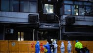 Medical staff in personal protective equipment (PPE) work in front of barriers of an area under lockdown, amid the coronavirus disease (COVID-19) pandemic, in Shanghai, China March 25, 2022. REUTERS/Aly Song