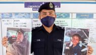 Mersing district police chief Cyril Edward shows the pictures of British man Adrian Peter Chesters and French woman Alexia Alexandra Molina, who were found safe after drifting at sea for two and a half days, during a news conference at Mersing, Johor, Malaysia, April 9, 2022. Reuters/Ebrahim Harris