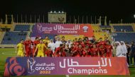 Al Arabi players and officials celebrate with the trophy after winning the QFA Cup at the Thani bin Jassim Stadium, yesterday.