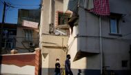 People wearing face masks walk past a residential building, after the lockdown placed to curb the coronavirus disease (COVID-19) outbreak was lifted in Shanghai, China June 2, 2022. Reuters/Aly Song
