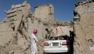 Afghan people try to retrieve a car from the debris of damaged houses after the recent earthquake in Wor Kali village in the Barmal district of Paktika province, Afghanistan, June 25, 2022. (REUTERS/Ali Khara)