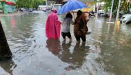 Pedestrians wade through floodwaters on a street amid heavy rainfall as Typhoon Chaba hits Sanya in Hainan province, China July 2, 2022. cnsphoto via REUTERS