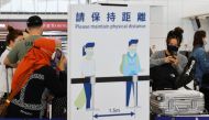 Travellers wearing face masks queue at the check-in counters of the Hong Kong International Airport amid the coronavirus disease (COVID-19) pandemic in Hong Kong, China, March 21, 2022. REUTERS/Tyrone Siu



