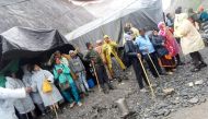 People stand outside tents after a cloudburst near the holy Amarnath cave shrine in Kashmir, July 8, 2022. (Reuters)