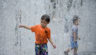 A child cools off in a fountain on a hot day, following a coronavirus disease (COVID-19) outbreak, in Shanghai, China July 12, 2022. REUTERS/Aly Song