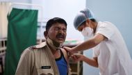 A policeman reacts as he receives a booster dose of the COVISHIELD vaccine against the coronavirus disease (COVID-19), manufactured by Serum Institute of India, at a vaccination centre in Mumbai, India, January 10, 2022. REUTERS/Francis Mascarenhas/File Photo