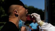 A man gets a swab test at a nucleic acid testing station, following a coronavirus disease (COVID-19) outbreak, in Beijing, China, July 14, 2022. REUTERS/Thomas Peter/File Photo