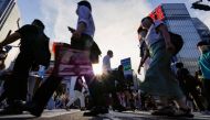 Passersby wearing protective face masks walk on the Shibuya crossing, amid the coronavirus disease (COVID-19) pandemic, in Tokyo, Japan July 28, 2022. (REUTERS/Issei Kato)