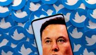 File Photo: An image of Elon Musk is seen on smartphone placed on printed Twitter logos in this picture illustration taken April 28, 2022. (REUTERS/Dado Ruvic)