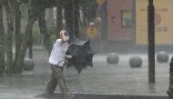 A man walks on the street in the heavy rain caused by Tropical Storm Meari in Hamamatsu, central Japan August 13, 2022, in this photo taken by Kyodo. Mandatory credit Kyodo via REUTERS
