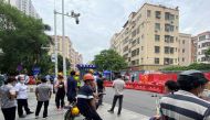 People watch as barricades are set up outside an entrance to Wanxia urban village as part of coronavirus disease (COVID-19) control measures in Shenzhen, Guangdong province, China August 29, 2022. REUTERS/David Kirton