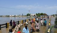 People cross a bridge amid flood waters, following rains and floods during the monsoon season in Puran Dhoro, Badin, Pakistan August 30, 2022. Reuters/Yasir Rajput