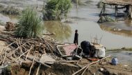 A flood victim stands amid the damages of his house, following rains and floods during the monsoon season, in Nowshera, Pakistan, on August 31, 2022. REUTERS/Fayaz Aziz/File Photo