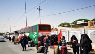 Iranian Shi'ite pilgrims gather around cars to leave Iraq, after political crisis, in Najaf, Iraq, on August 30, 2022. REUTERS/Ahmed Saeed 