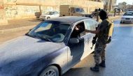A member of the Libyan security forces checks a driver's document as they are deployed in Misrata, Libya November 19, 2020. REUTERS/Ayman Al-Sahili/