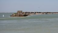 A view of houses on an embankment that partially eroded amid floodwater, following rains and floods during the monsoon season in Bhan Syedabad, Pakistan, September 3, 2022. (REUTERS/Yasir Rajput)