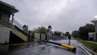 A man walk past an electricity pole that was damaged by Hurricane Fiona in Yauco, Puerto Rico, on September 18, 2022. REUTERS/Ricardo Arduengo