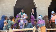 Hollywood actress and UN humanitarian Angelina Jolie listens to displaced women following rains and floods during the monsoon season, in village Ibrahim Chandio, Dadu, Pakistan, on September 20, 2022. (IRC/Saima Javaid via REUTERS) 