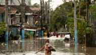 Residents wade through waist-deep flood waters after Super Typhoon Noru, in San Miguel, Bulacan province, Philippines, September 26, 2022. REUTERS/Eloisa Lopez