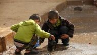 File Photo: Children remove trash blocking the drains in the Al Inzarat district in Aleppo, on February 17, 2013. (REUTERS/Hamid Khatib)