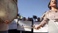 Women carry banners and play instruments during a protest over the death of 22-year-old Kurdish woman Mahsa Amini in Iran, in the Kurdish-controlled city of Qamishli, northeastern Syria on September 26, 2022.   REUTERS/Orhan Qereman
