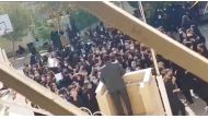 Female protesters react and chant towards a man standing at a podium in Shiraz, Fars province, Iran, on October 4, 2022 in this still image from a video obtained by REUTER