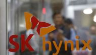 Employees walk past the logo of SK Hynix at its headquarters in Seongnam, South Korea, on April 25, 2016.  File Photo / Reuters