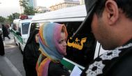 Morality police take down the name of a detained woman during a crackdown on 