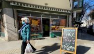 A shopper walks past a placard that reads 