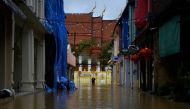 A man walks in a flooded street in the tourist area of Phuket Town in Phuket, Thailand October 16, 2022. REUTERS/Chanchai Hatsut