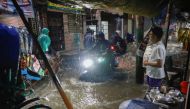 People ride rickshaws and motorcycles on a flooded street, amid continuous rain before Cyclone Sitrang hits the country in Dhaka, Bangladesh, October 24, 2022. (REUTERS/Mohammad Ponir Hossain)