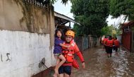 A Philippine Coast Guard (PCG) rescuer evacuates a child following flooding due to Tropical Storm Nalgae, in Zamboanga, Philippines, October 29, 2022. Philippine Coast Guard/Handout via Reuters