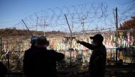 FILE PHOTO: Men look at a military fence decorated with ribbons bearing messages wishing for the reunification of the two Koreas near the demilitarized zone separating the two Koreas, in Paju, South Korea, November 4, 2022. REUTERS/Kim Hong-Ji