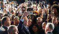 US President Joe Biden (C) poses for a selfie with supporters during a rally for Democratic candidates, including New York Governor Kathy Hochul, at Sarah Lawrence College in Bronxville, New York, on November 6, 2022. (Photo by SAUL LOEB / AFP)
 