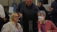 A neutral worker and a Republican and Democratic representative adjudicate ballots cast in the U.S. midterm elections at the Maricopa County Tabulation and Election Center in Phoenix, Arizona, U.S., November 9, 2022. Reuters/Brian Snyder