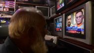 A man watches a news television broadcast of the nomination of the next Pakistan's army Chief General Syed Asim Munir (on television 2R), at a market in Karachi on November 24, 2022. (AFP/Asif Hassan)