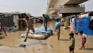 A policeman jumps off a makeshift raft after wading through a flooded area of a slum on the banks of the river Yamuna in New Delhi, India, September 28, 2022. REUTERS/Anushree Fadnavis/File Photo