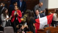 Peruvian congress members react after the vote for the impeachment of President Pedro Castillo in Lima on December 7, 2022.  (Photo by Cris BOURONCLE / AFP)