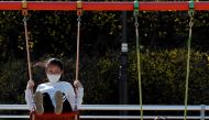 Children wearing masks following the rise in confirmed cases of coronavirus disease (COVID-19), play on the swings at a park in Daegu, South Korea, March 14, 2020. REUTERS/Kim Kyung-Hoon/File Photo