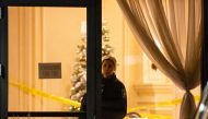 A police officer looks out from the lobby after a fatal mass shooting at a condominium building in the Toronto suburb of Vaughan, Ontario, Canada December 19, 2022. REUTERS/Carlos Osorio