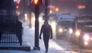 A pedestrian navigates a snow-covered sidewalk as temperatures hang in the single-digits on December 22, 2022 in Chicago, Illinois. Photo by SCOTT OLSON / GETTY IMAGES NORTH AMERICA / Getty Images via AFP