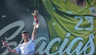 The goalkeeper of the Argentine soccer team Emiliano Martinez, holds a gold medal and gold glove trophy awarded by FIFA during a tribute to him, in Mar del Plata, Argentina, on December 22, 2022, upon his return to his hometown after winning the Qatar 2022 World Cup tournament. (Photo by Mara Sosti / AFP)