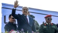 Libya's eastern military chief Khalifa Haftar (second left) gestures after a speech a rally marking the 71st anniversary of the country's independence from Italy in the eastern city of Benghazi on December 24, 2022. (Photo by Abdullah DOMA / AFP)
