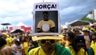 In this file photo taken on December 05, 2022 a fan of Brazil wears a hat with an image of Brazilian football legend Pele ahead of the start of the Qatar 2022 World Cup round of 16 football match between Brazil and South Korea at the FIFA Fan Festival in Copacabana beach, Rio de Janeiro, Brazil. (Photo by MAURO PIMENTEL / AFP)
 