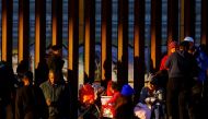 A migrant girl holds a Christmas present, as she queues with her family near the border wall to request asylum in El Paso, Texas, US, seen from Ciudad Juarez, Mexico, on December 25, 2022. REUTERS/Jose Luis Gonzalez
