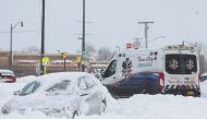 An ambulance passes an abandon car during a winter storm that hit the Buffalo region, in Amherst, New York, US, on December 26, 2022. REUTERS/Brendan McDermid