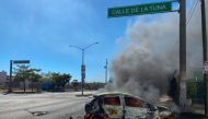 A burning car is seen on the street during an operation to arrest the son of Joaquin 'El Chapo' Guzman, Ovidio Guzman, in Culiacan, Sinaloa state, Mexico, on January 5, 2023. (Photo by Juan Carlos Cruz / AFP)