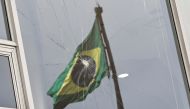 Brazil's flag is reflected on a broken window, after the supporters of Brazil's former President Jair Bolsonaro participated in an anti-democratic riot at Planalto Palace, in Brasilia, Brazil, January 9, 2023. (REUTERS/Ueslei Marcelino)