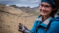 A woman holds a fossil at the area where scientists discovered megaraptor fossils at 'Guido' hill in the Chilean Patagonia area, close to Torres del Paine park, in Magallanes and Antarctic region, Chile in this undated handout photo provided by the Instituto Chileno Antartico on January 16, 2023. (Instituto Chileno Antartico/Handout via REUTERS) 
