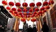 People walk under lanterns along an alley ahead of the lunar new year in Beijing on January 21, 2023. (Photo by Noel CELIS / AFP)